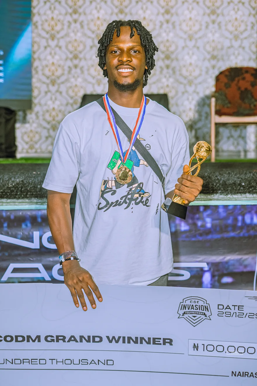 Call of Duty Mobile champion smiling with medal and trophy